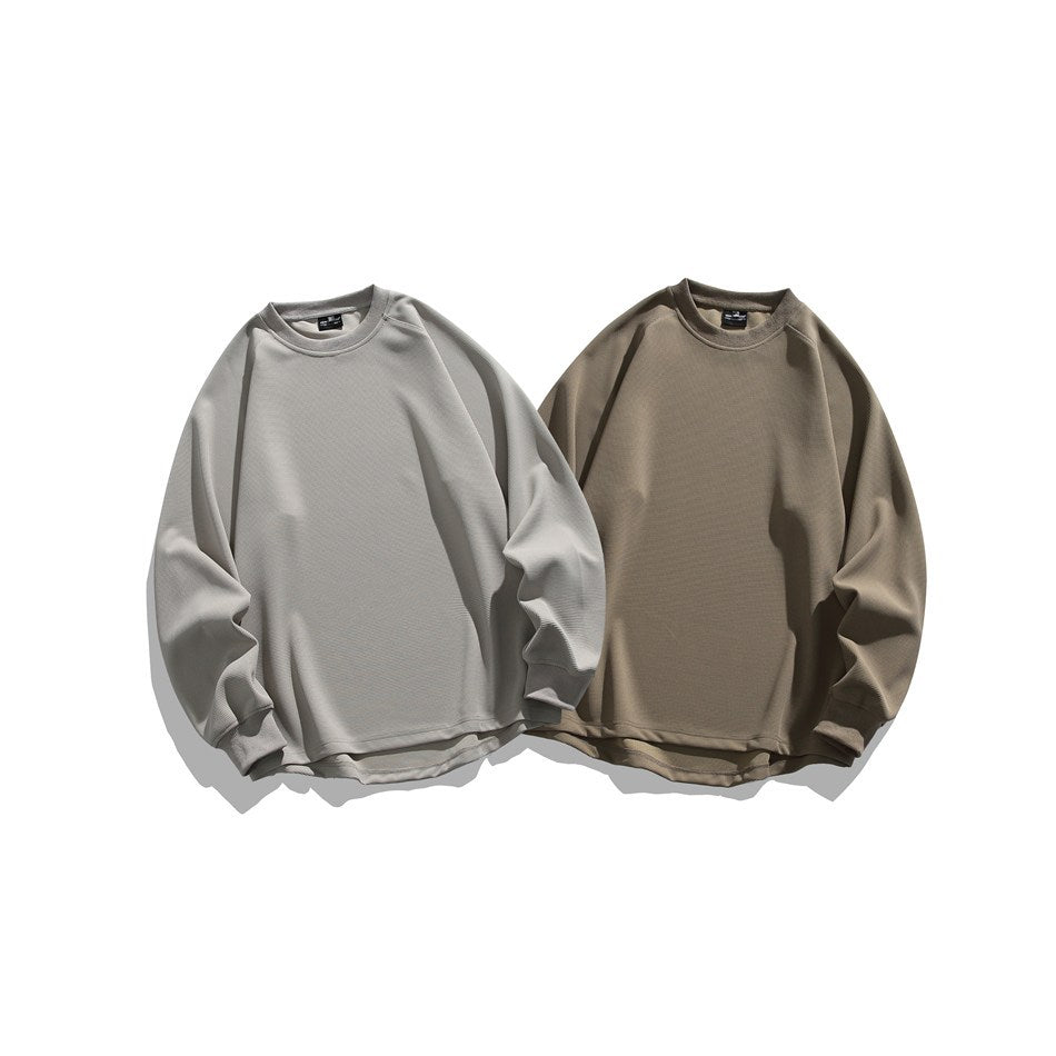 Front view of two plain crewneck sweatshirts, one light gray and one taupe, displayed side by side.