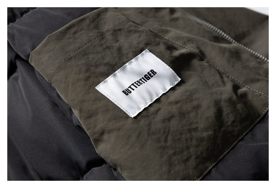 Close-up of a white BUTTERTIGER label sewn onto dark olive jacket fabric.