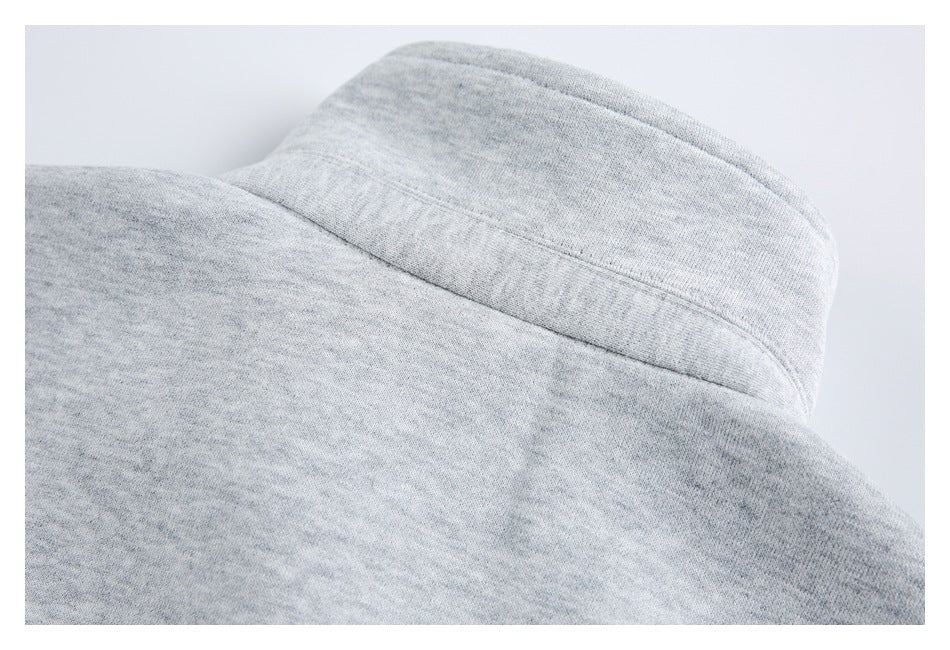 Close-up of a raised collar and back seam on a light gray heathered garment.