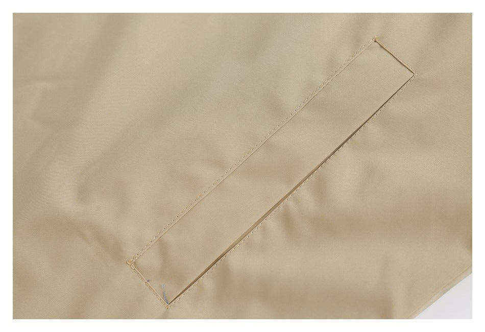 Close-up of a long, narrow welt pocket opening stitched into beige coat fabric.