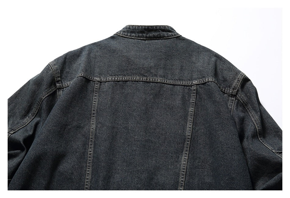 Back view of a dark charcoal denim jacket with a shoulder yoke and vertical panel seams.
