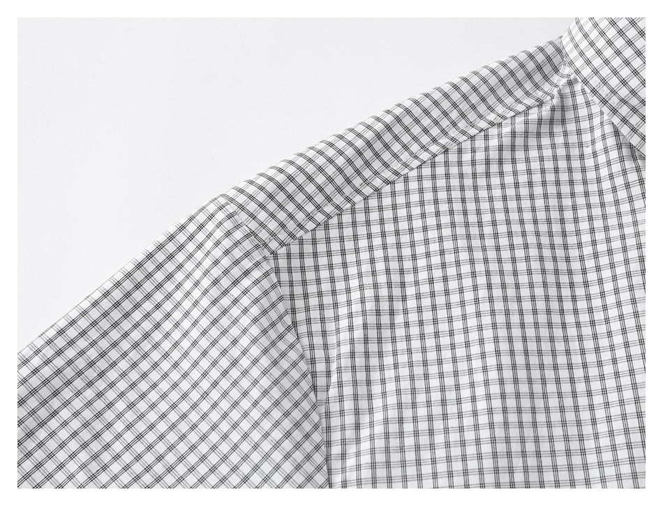 Close-up of the black grid-check shirt's shoulder seam and sleeve.