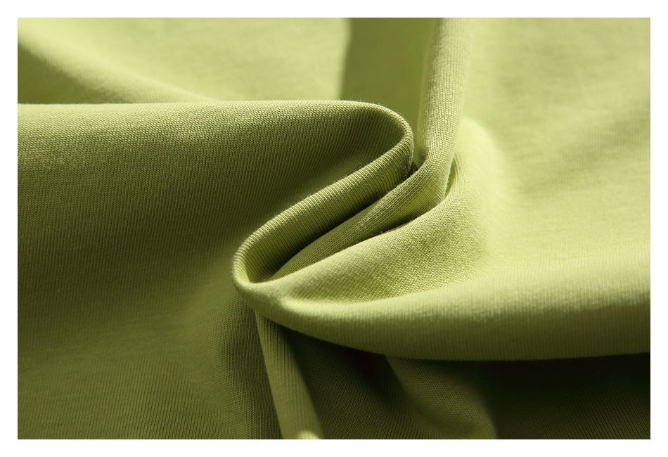 Close-up of olive-green knit fabric showing its fine texture and soft folds.