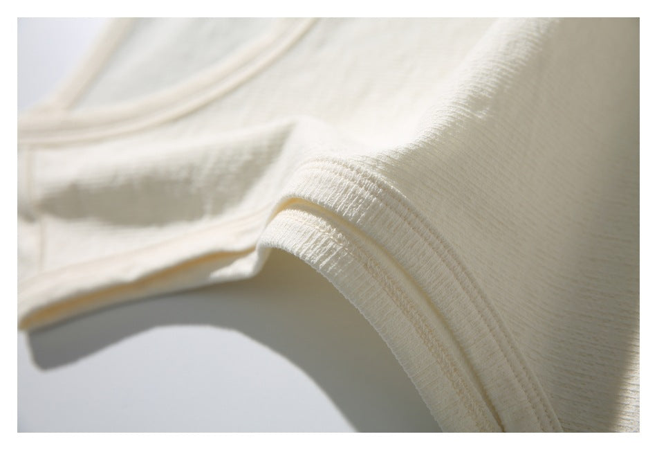 Close-up of cream fabric showing a curved, neatly stitched folded edge.