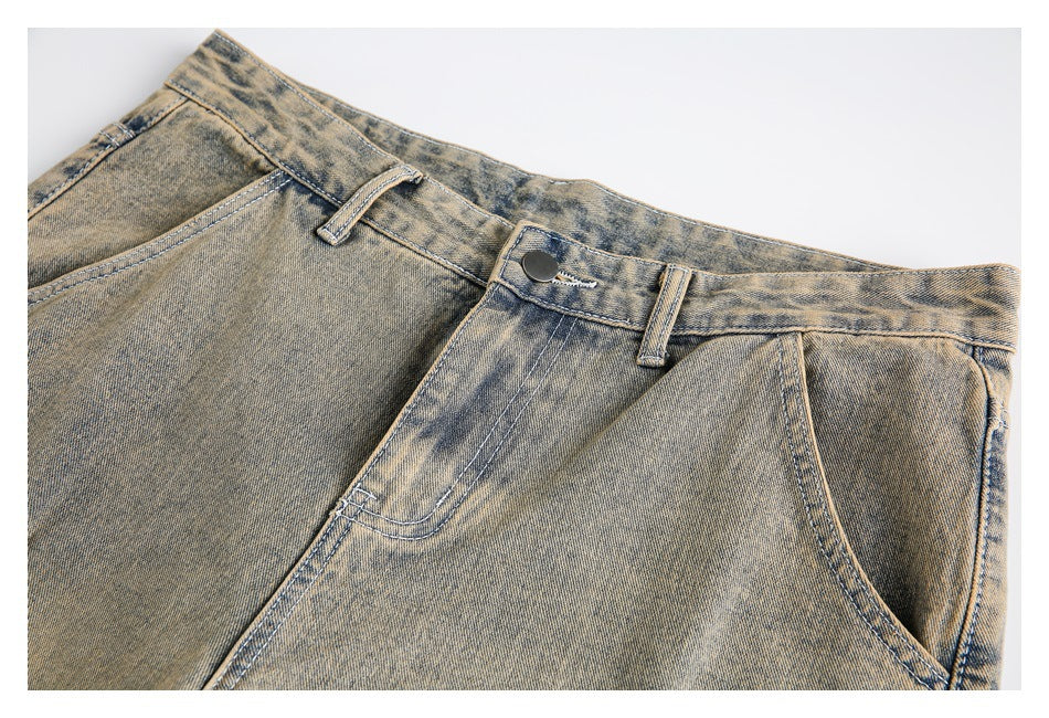 Close-up of tan and dark-wash jeans showing the waistband, button, belt loops, and front pockets.