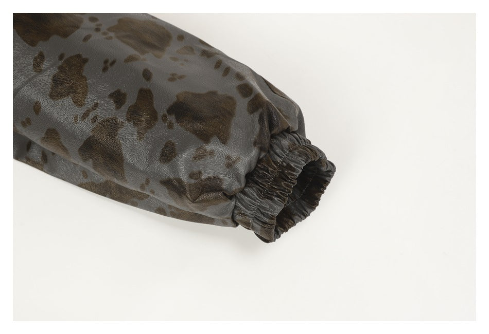 Close-up of an elastic cuff on a sleeve with glossy gray-brown spotted fabric.