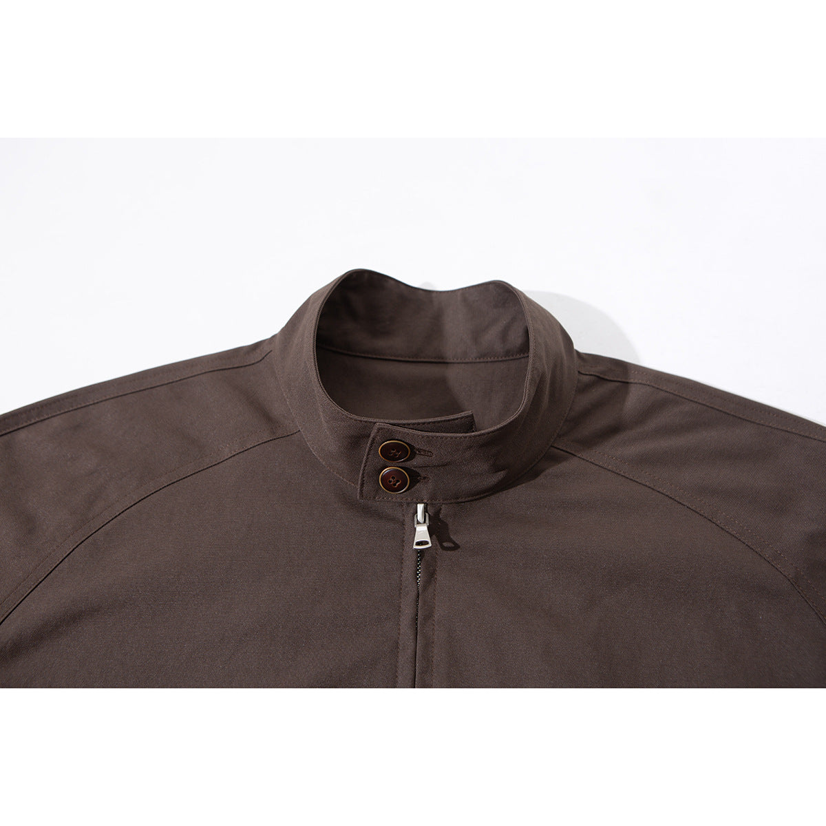 Close-up of a dark brown jacket collar with two buttons and a central zipper.