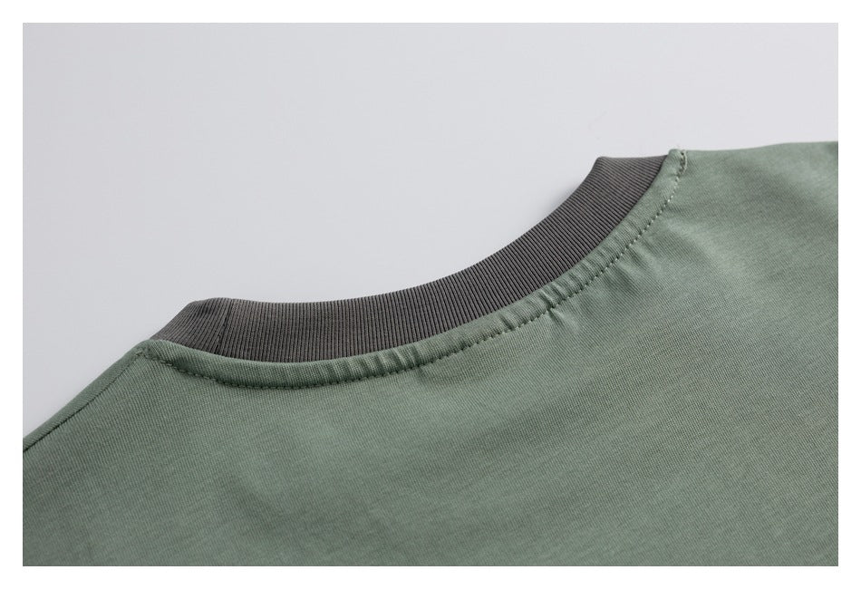 Close-up of a sage-green neckline with a dark ribbed crew collar.