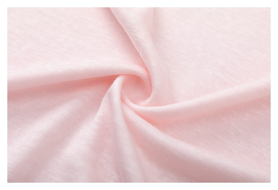 Close-up of pale pink fabric gathered into folds, showing its fine knit texture.