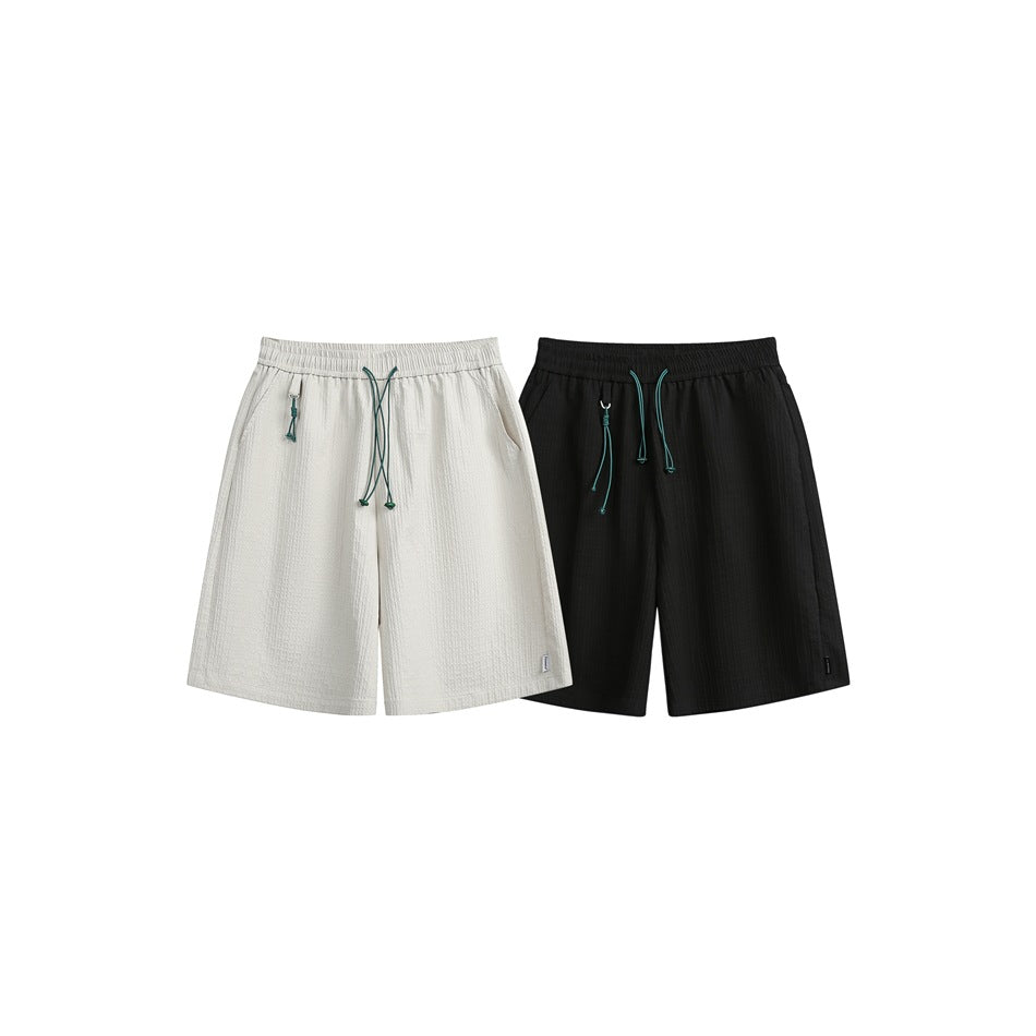 Light beige and black knee-length shorts shown side by side, both with elastic waists and teal drawstrings.