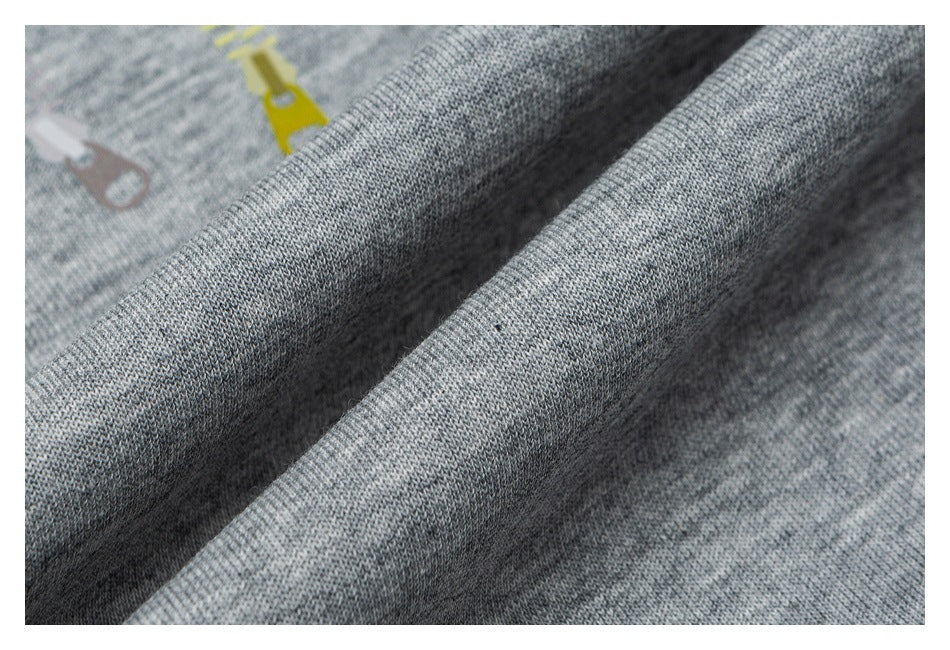 Close-up of folded gray heathered knit fabric with partial yellow and pale pink zipper-shaped prints.