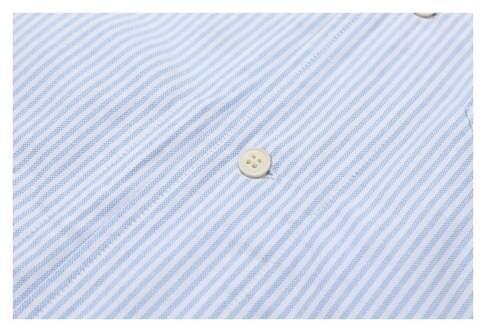 Extreme close-up of blue-and-white shirt stripes and a cream four-hole button.