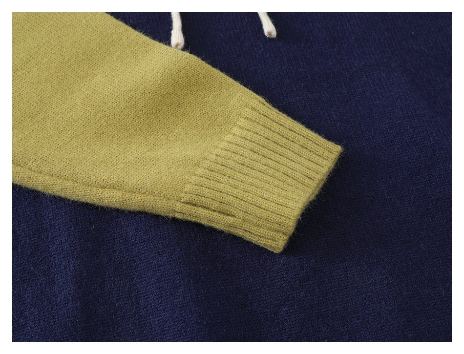 Close-up of a pale yellow-green knit sleeve with a ribbed cuff against the navy body.
