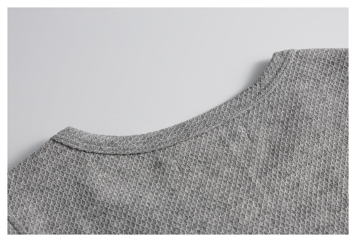 Close-up of the gray textured top's rounded neckline and shoulder area.