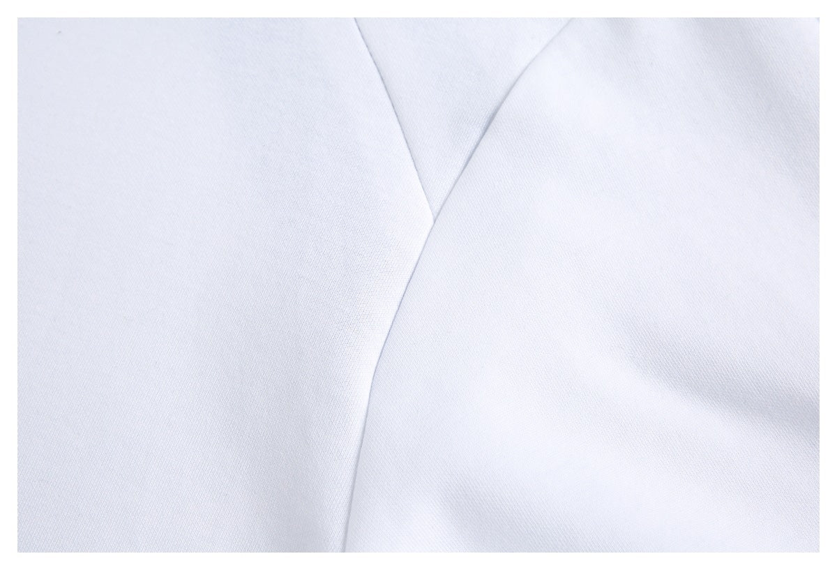 Close-up of a white garment's intersecting stitched seams.