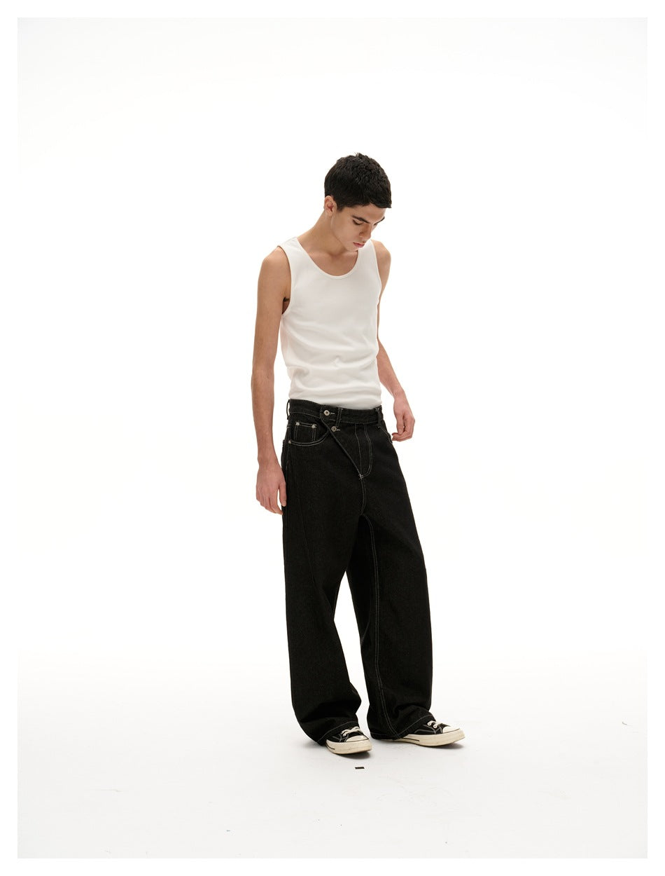 Full-length angled view of a model wearing a white sleeveless tank and loose black jeans.