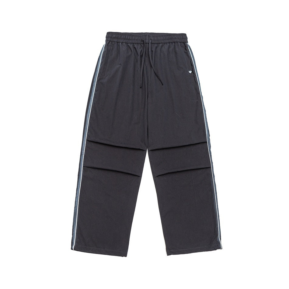Dark gray wide-leg drawstring pants with blue-gray and white side stripe trim and pleated knees, flat lay front view