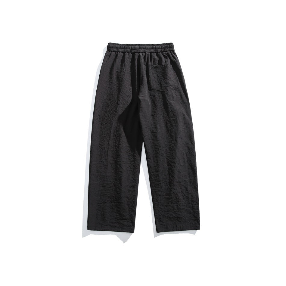 Black wide-leg pants back view with elastic waistband and one back patch pocket, flat lay