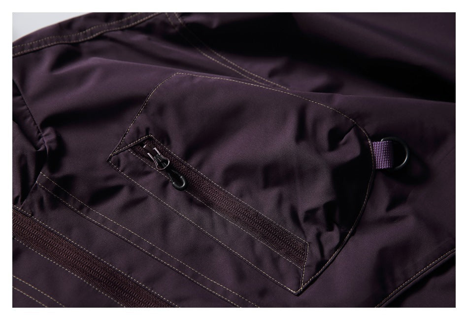 Close-up of a large dark plum jacket pocket with a diagonal zipper and small loop detail.