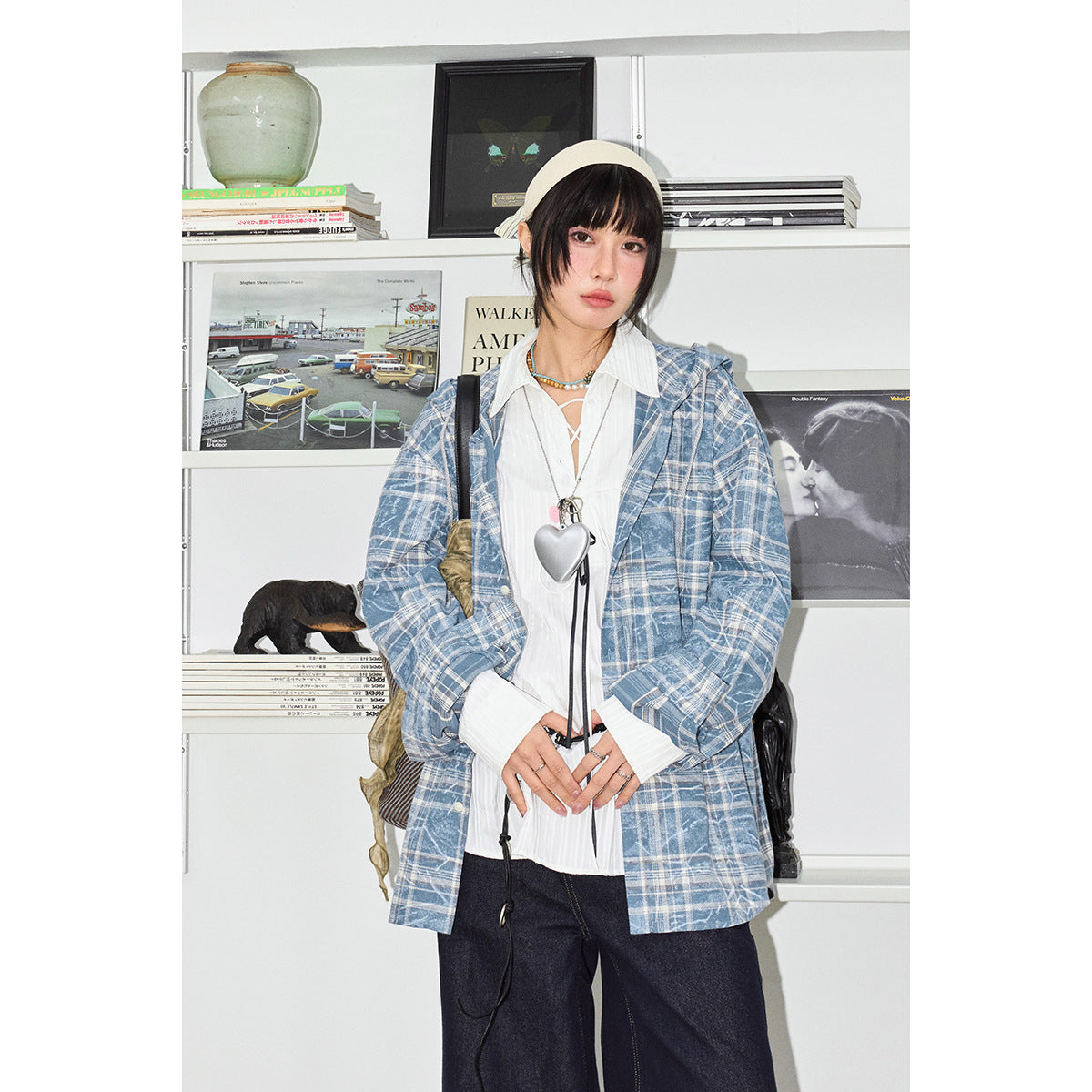 Front view of a model in an oversized blue-and-white plaid jacket over a white blouse and dark wide-leg jeans.