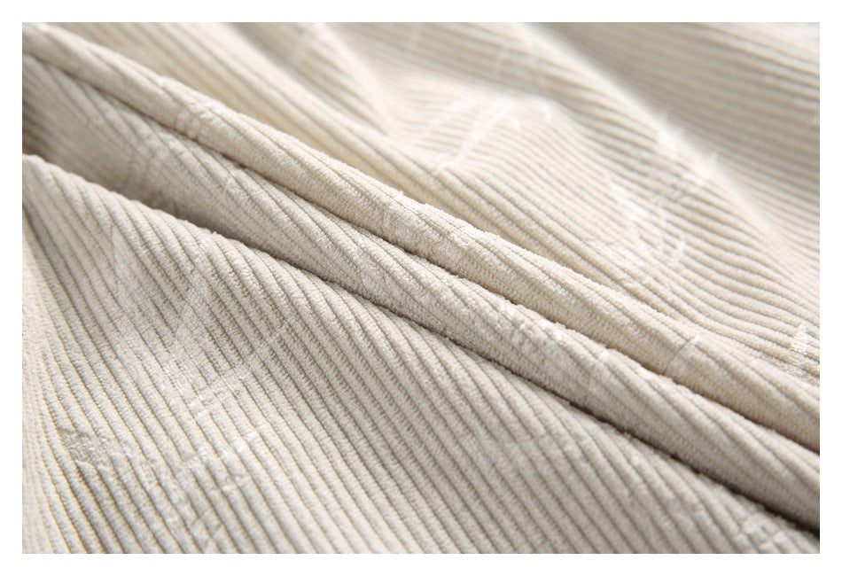 Close-up of cream ribbed fabric and a stitched seam running diagonally across the garment.