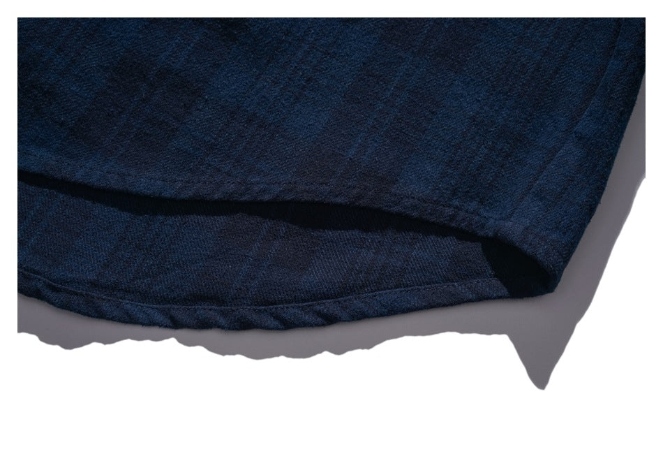 Close-up of the curved hem and stitching on the dark navy shirt.