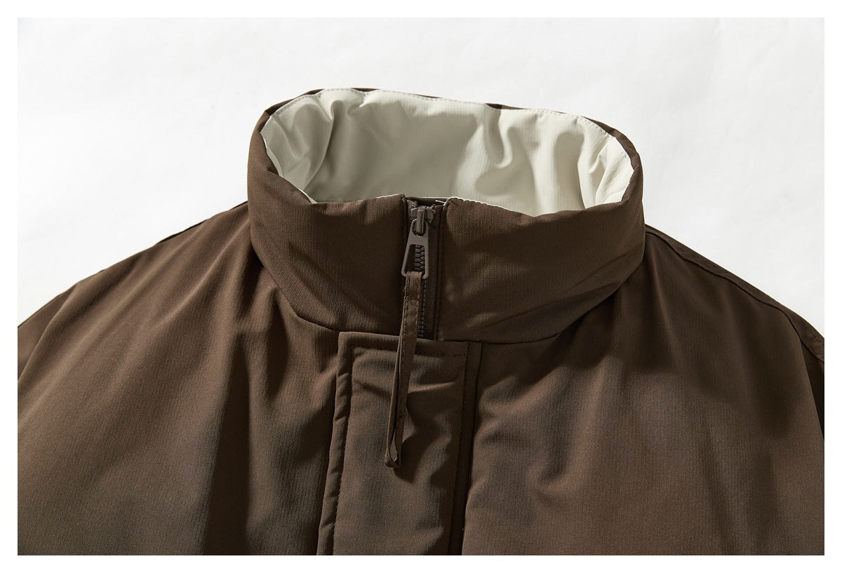 Close-up of the brown jacket's high collar, cream inner lining, and front zipper with a long pull.
