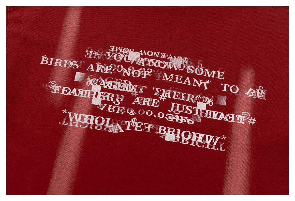 Close-up of distressed white English lettering printed on deep red fabric.