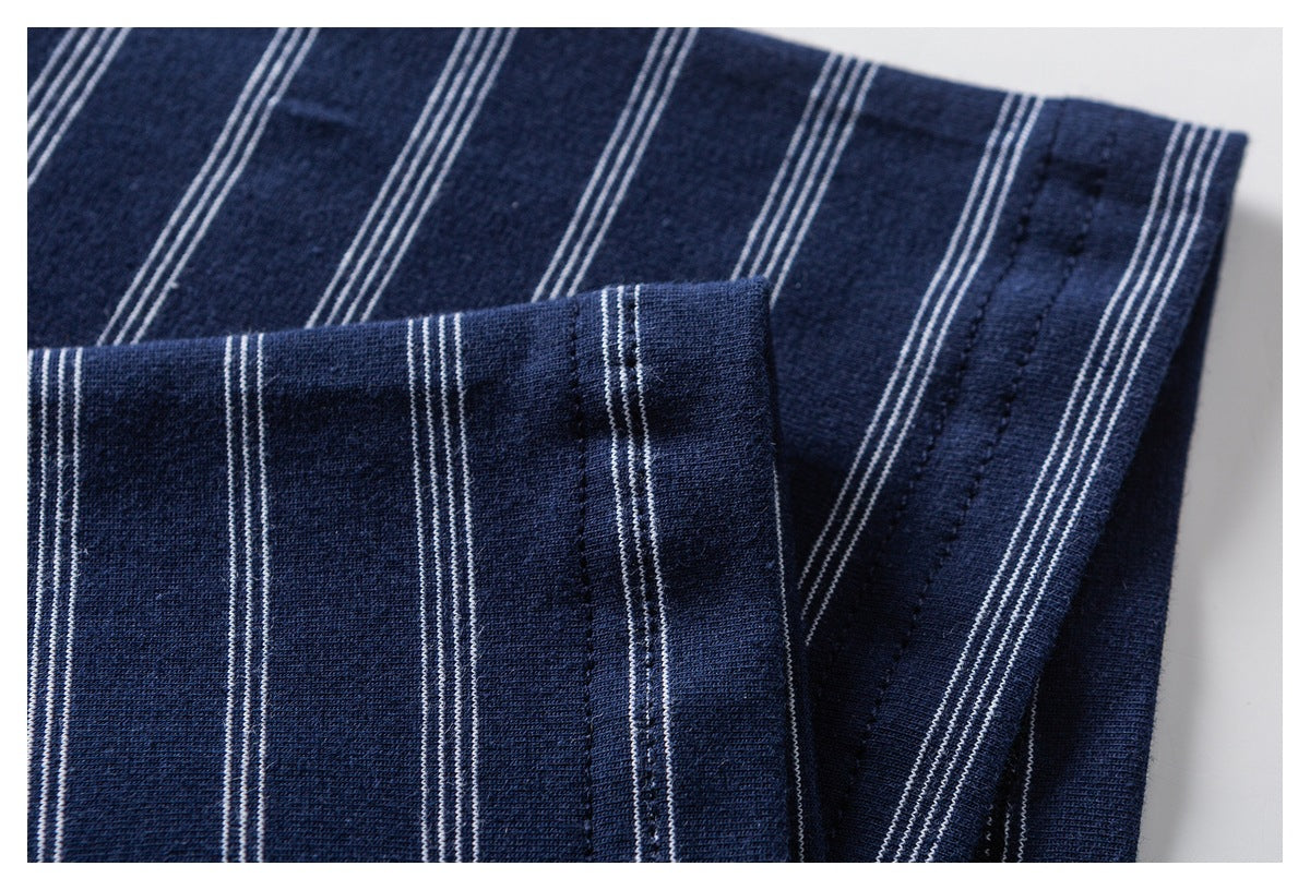Close-up of navy striped fabric showing a folded, stitched edge and parallel white lines.