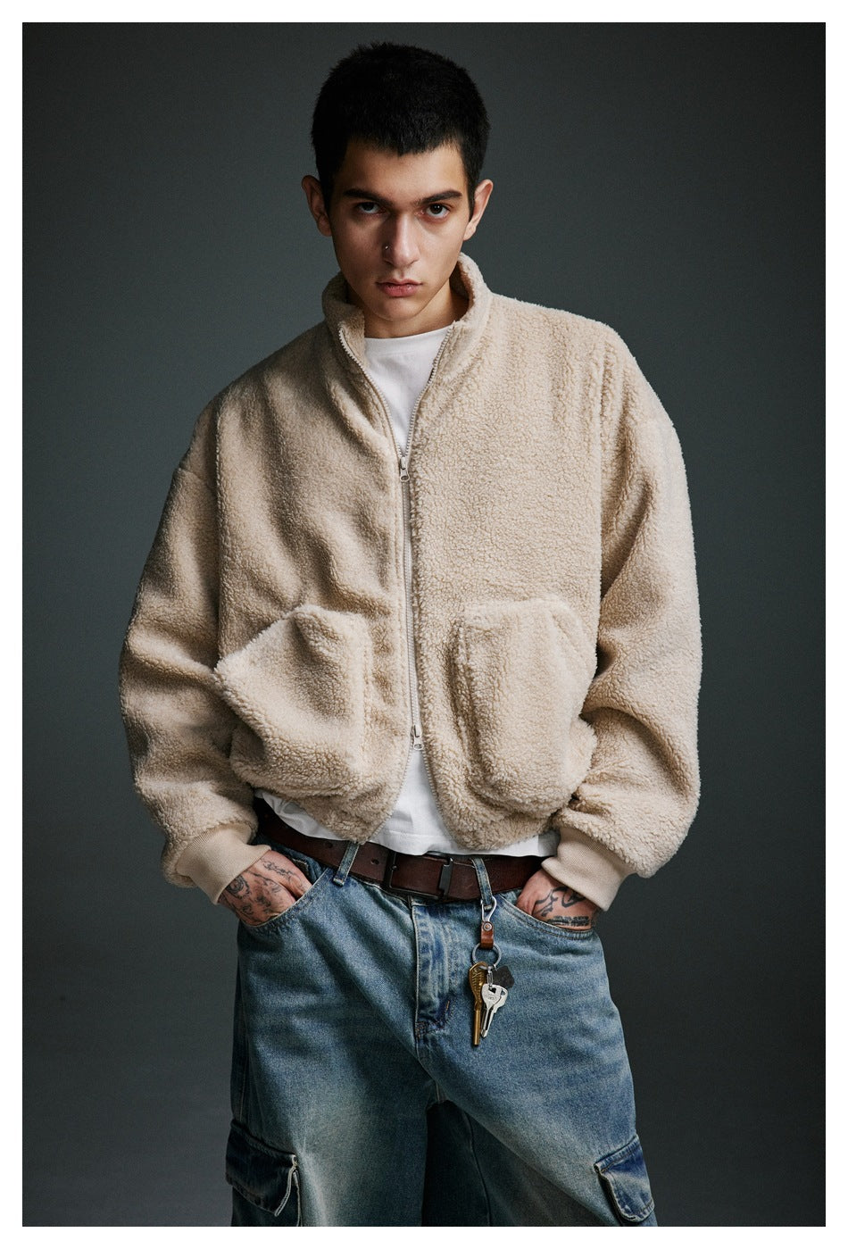 Front view of a model in a beige zip-up fleece jacket with a stand collar and two large pockets.