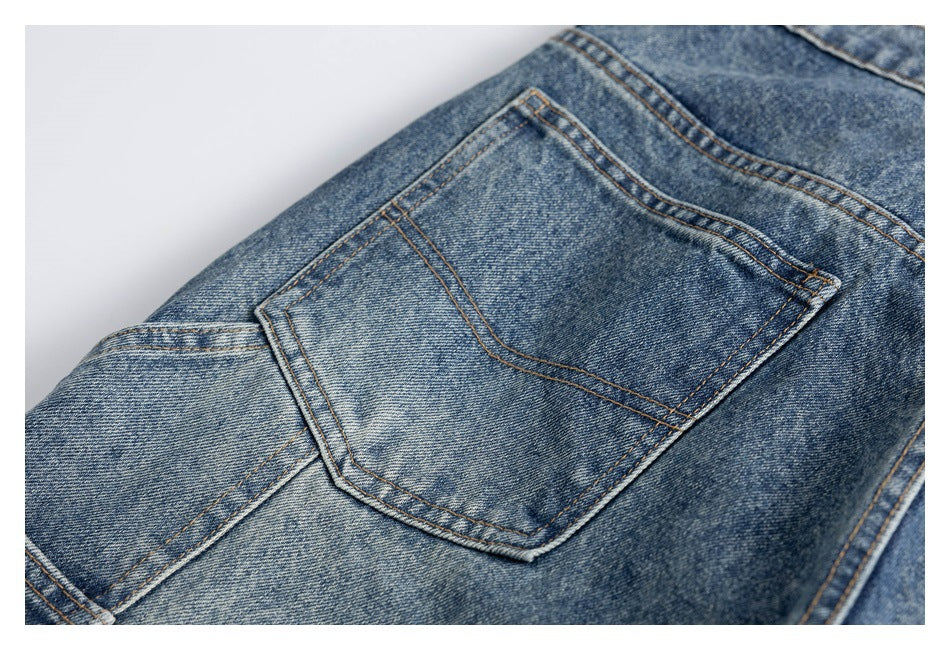 Close-up of a blue denim jeans back pocket with contrast stitching and faded wash.
