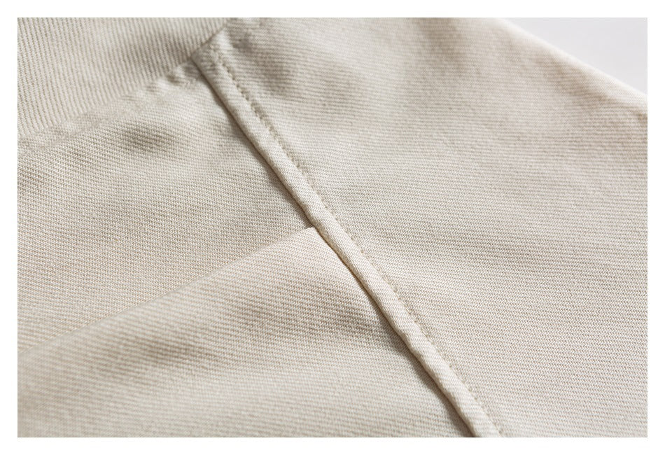 Close-up of a cream shirt's chest pocket edge and stitched seam.
