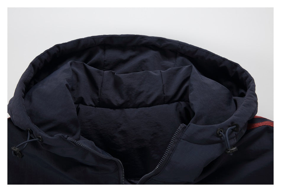 Close-up of a dark navy jacket's open hood, lining, zipper, and drawcord toggles.