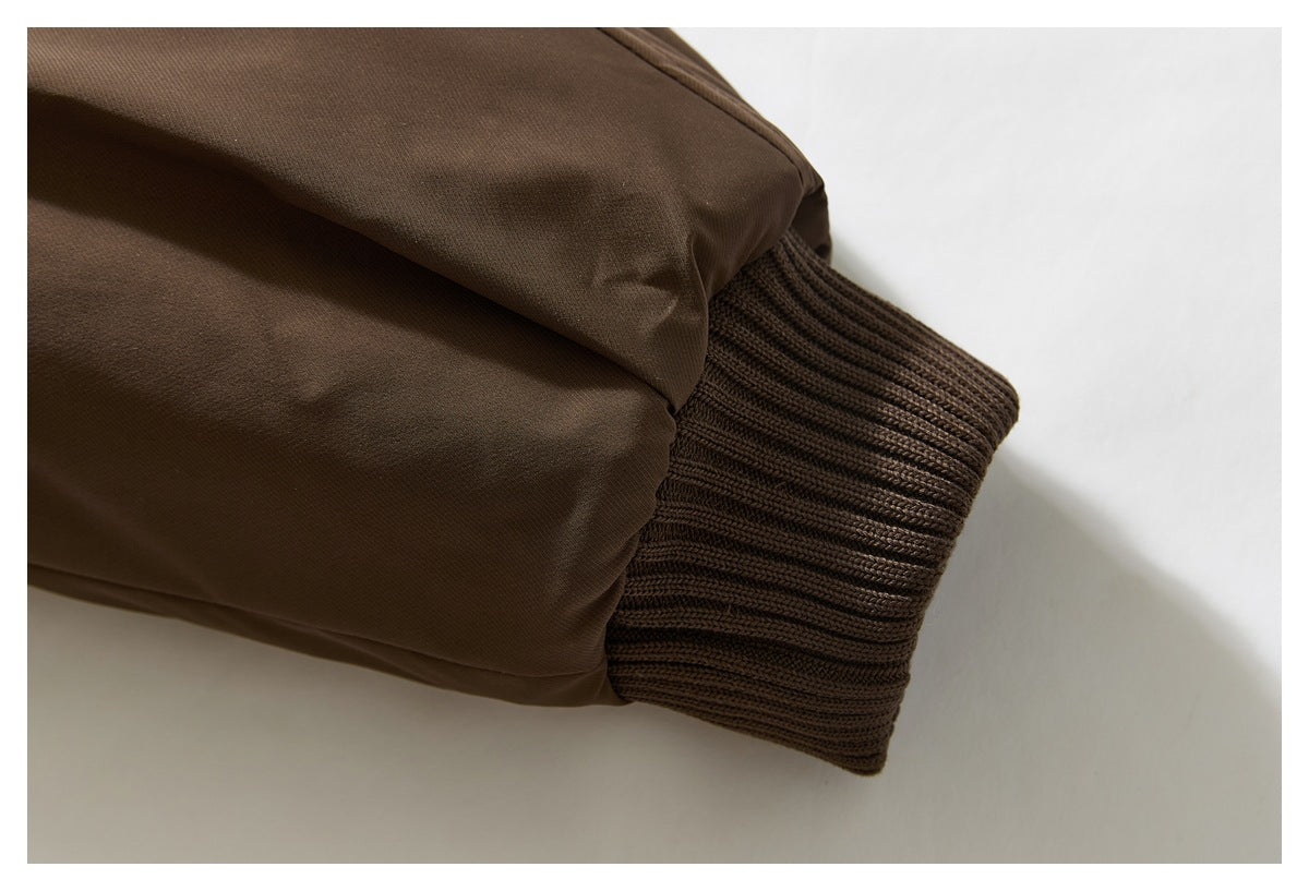 Close-up of a brown jacket sleeve ending in a wide ribbed knit cuff.