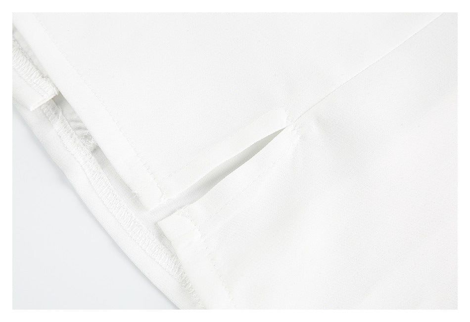 Close-up of white garment fabric showing an interior finished seam and folded edge.