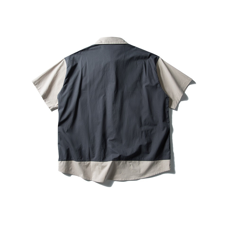 Back of navy short-sleeve layered shirt with beige sleeves, collar and beige hem band, flat lay