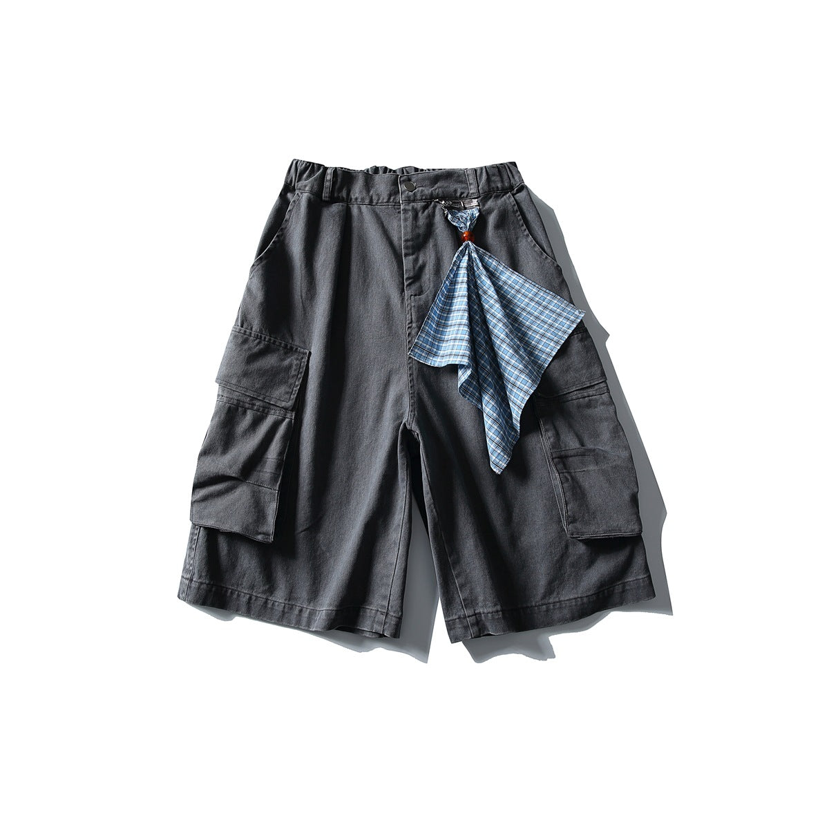 Gray cargo shorts with large side flap pockets and a blue plaid scarf hanging from the front zipper pull