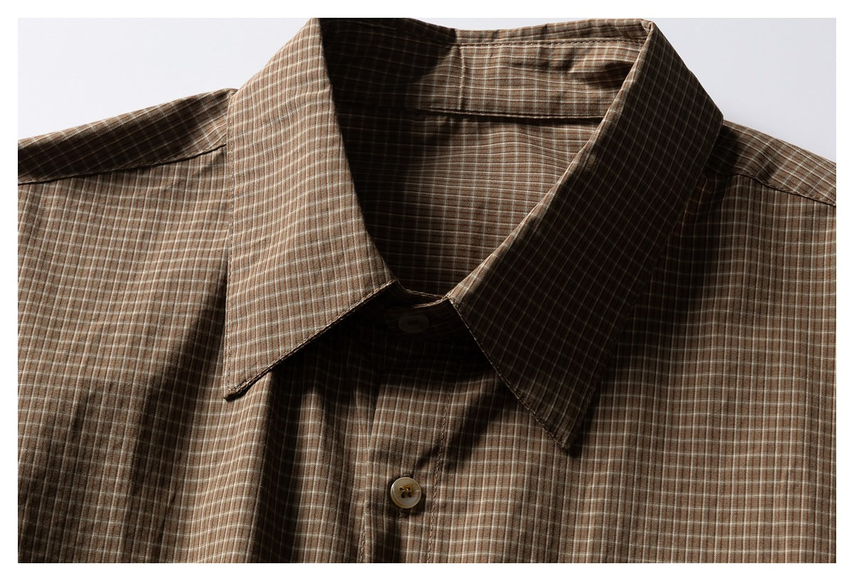 Close-up of the brown plaid shirt's pointed collar and upper button placket.