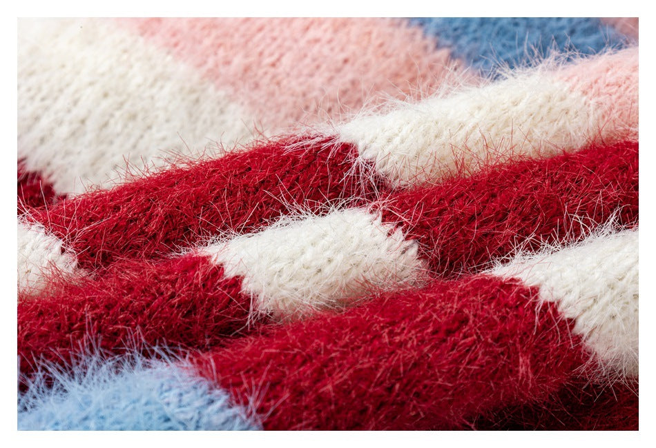 Extreme close-up showing the cardigan's fuzzy knit texture and red, cream, pink, and blue stripes.