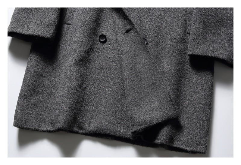 Close view of a charcoal gray coat front, showing black buttons, sleeves, and the lower hem.