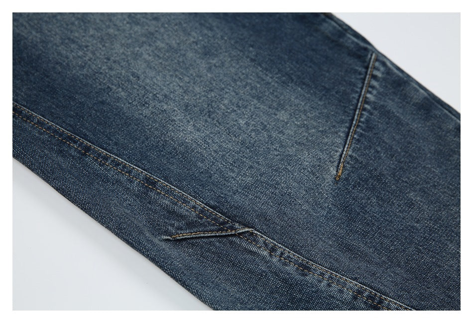 Close-up of dark blue jeans showing leg seams and contrasting stitching.