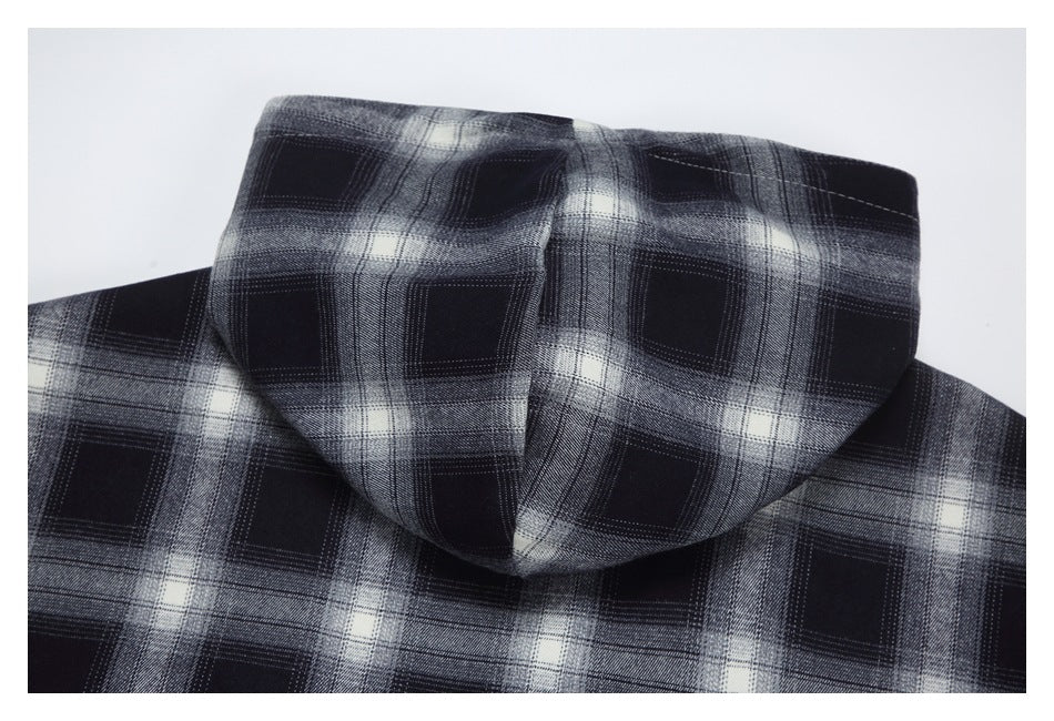 Back view of a black, gray, and white plaid garment showing its hood and shoulders.