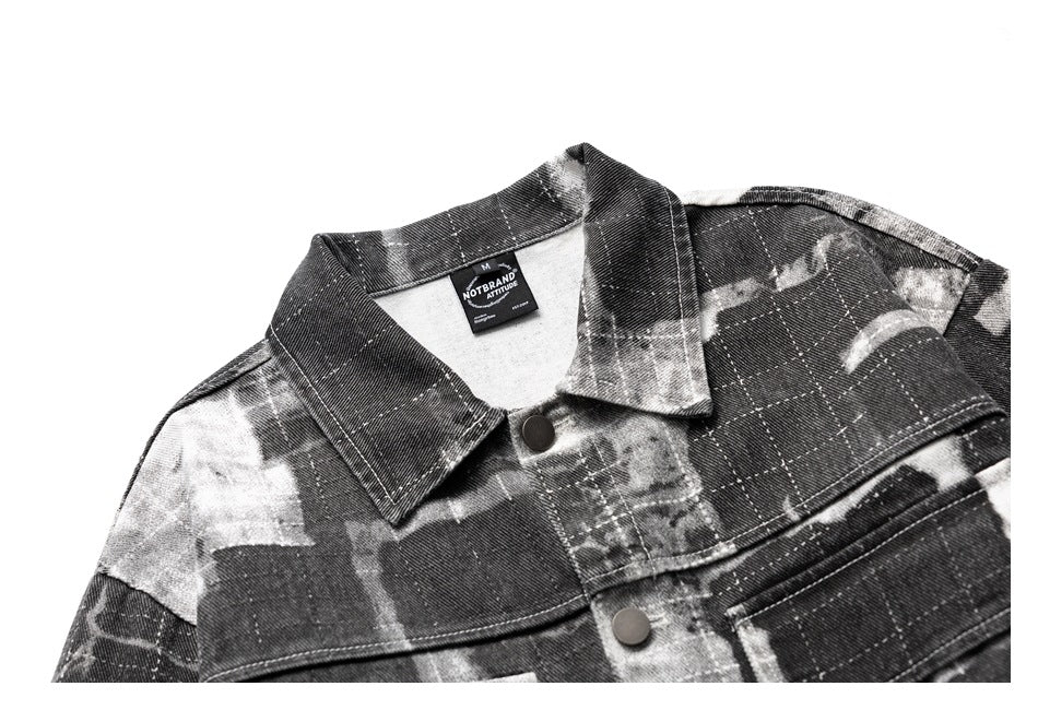 Cropped front view of a charcoal and gray abstract plaid jacket with a pointed collar and snap buttons.