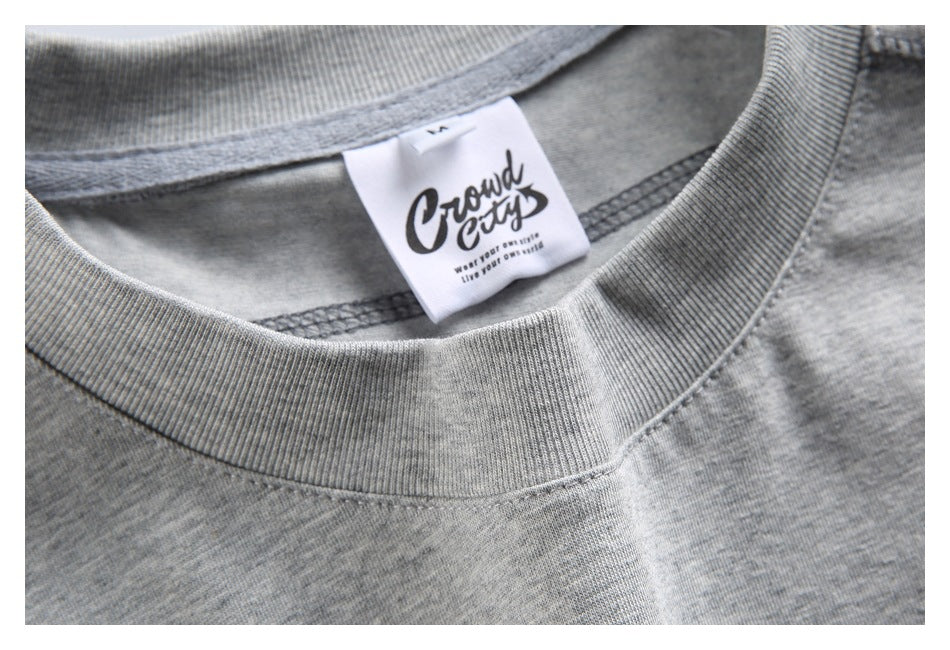 Close-up of a heather-gray crew-neck shirt with a white “Crowd City” neck label.