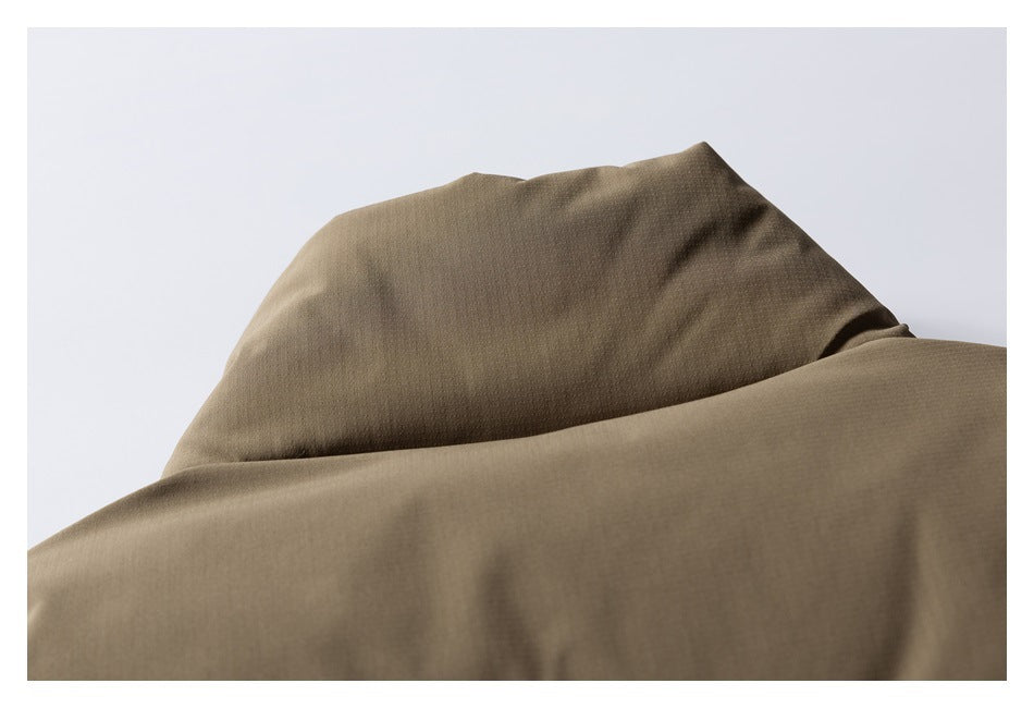 Close-up of the raised collar area of an olive-brown garment against a pale background.