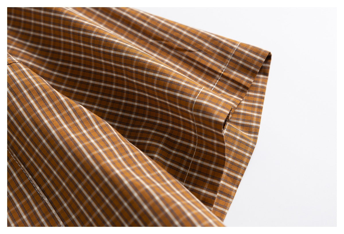 Close-up of the plaid shirt sleeve cuff and its stitched edge.