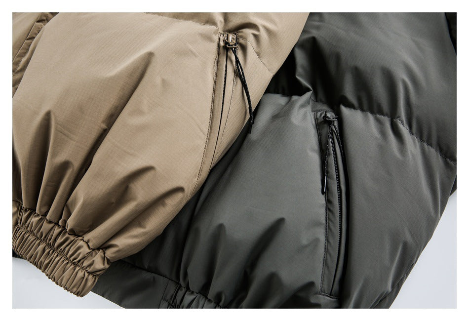 Close-up of beige and charcoal padded garments with vertical zip pockets and gathered elastic hems.