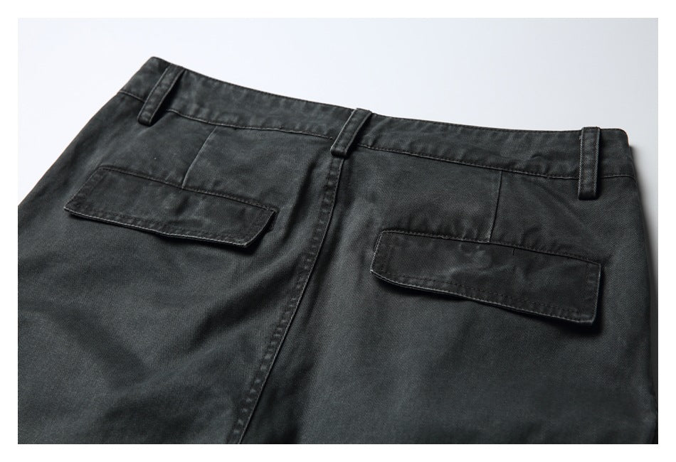 Close-up of charcoal trousers from the back, showing the waistband, belt loops and two flap pockets.