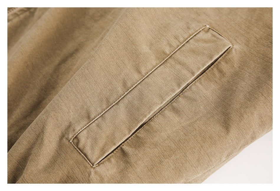 Close-up of a long, narrow welt pocket on tan fabric.