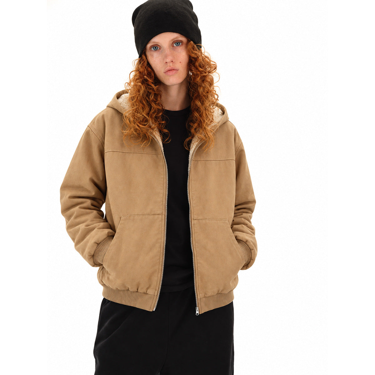 Model wearing a tan zip-up hooded jacket with cream lining, ribbed cuffs and hem, and front pockets.
